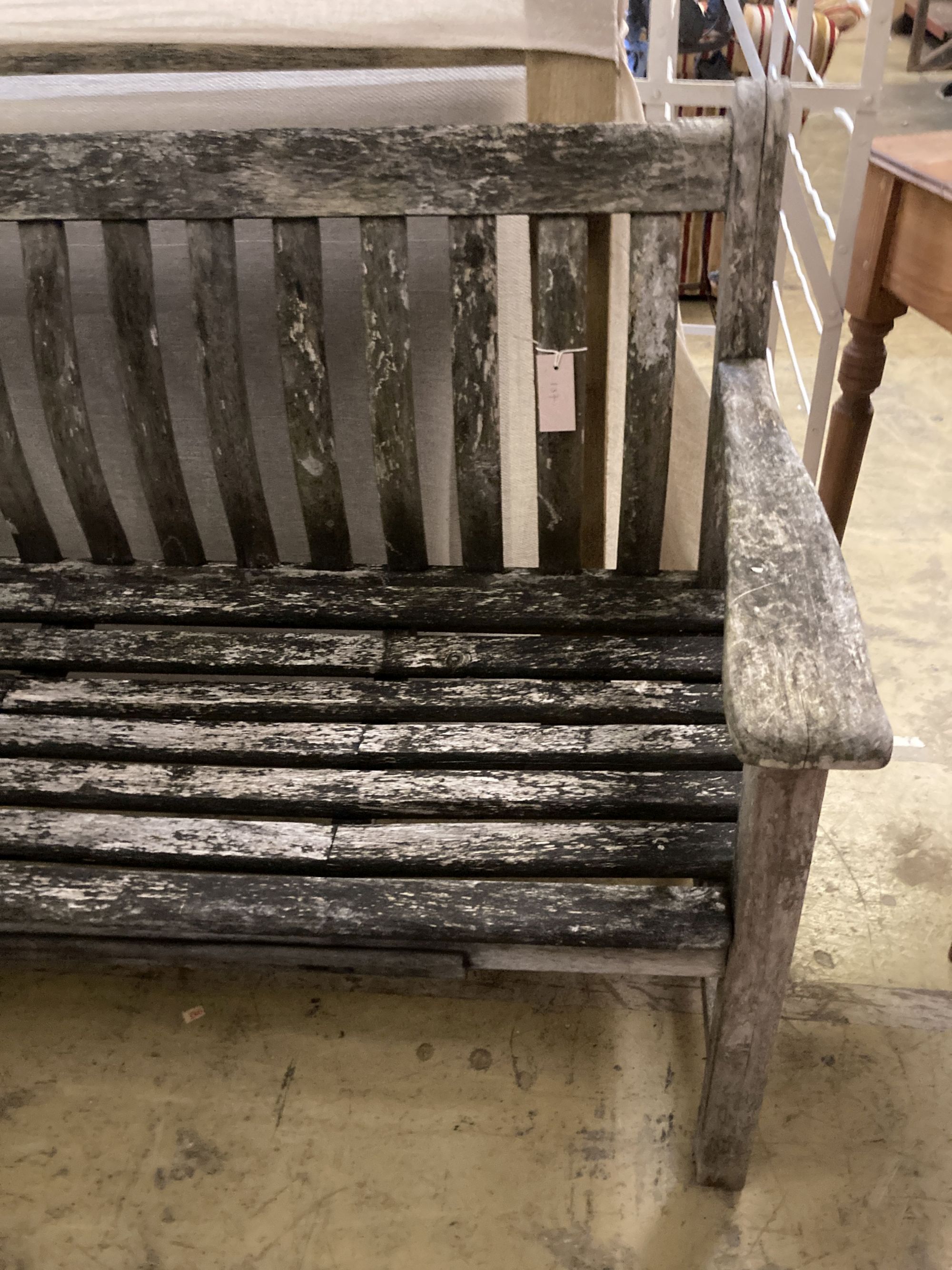 A weathered teak garden bench, length 150cm, depth 55cm, height 86cm